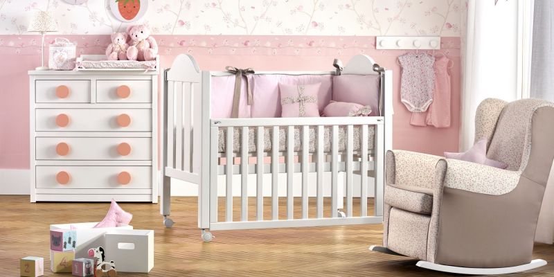 Habitación rosa con cuna y mecedora