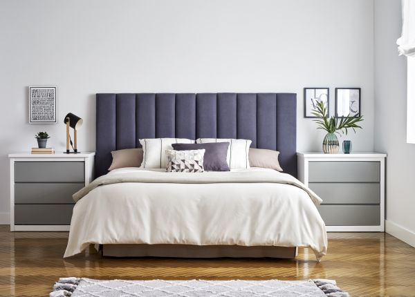 Cabecero tapizado en color azul con mesitas de noche de gran capacidad